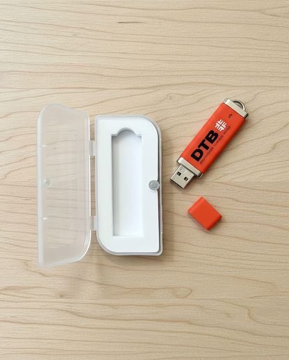 USB-Stick mit Kappe und Box auf hellem Holz